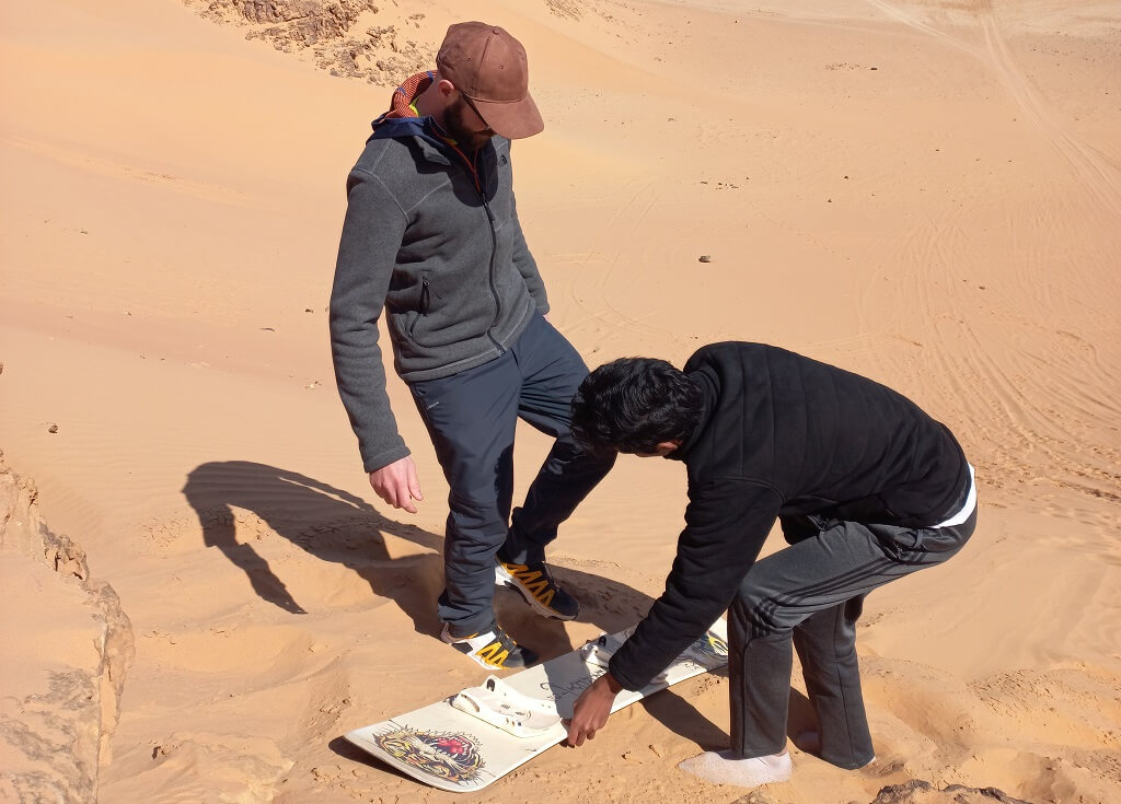 Sandboarding durante un viaggio in Giordania nel deserto